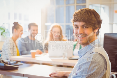 Portrait of smiling young businessman with colleagues