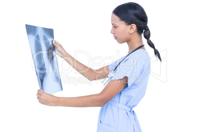 Serious young doctor looking at x-ray