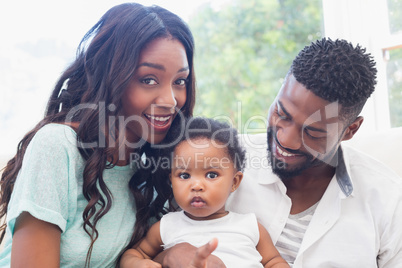 Happy couple with baby girl on couch