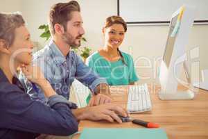 Colleagues using laptop at office