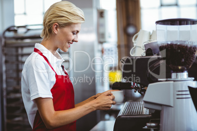 Pretty barista using the coffee machine Pretty barista using the coffee machine