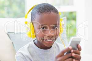 Little boy listening to music on the couch