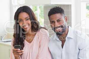 Happy couple using their phones at breakfast