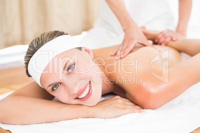 Pretty blonde enjoying a massage smiling at camera