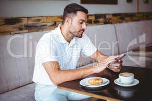 Young man having cup of coffee and pastry