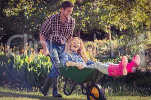 Man pushing his girlfriend in a wheelbarrow