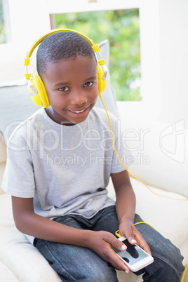 Little boy listening to music on the couch