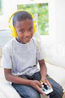 Little boy listening to music on the couch