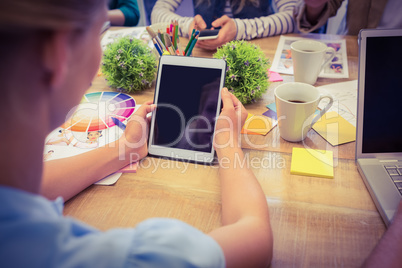 Rear view of casual businesswoman using tablet