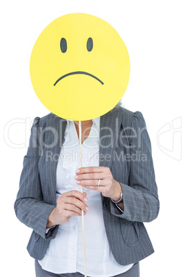 Businesswoman holding sad smiley face