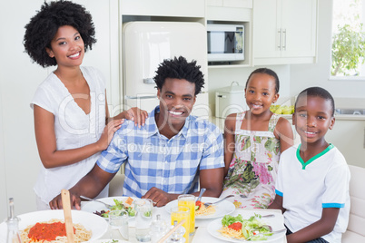 Happy family sitting down to dinner together