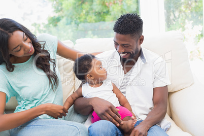 Happy couple with their baby girl on couch Happy couple with their baby girl on couch