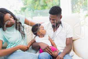 Happy couple with their baby girl on couch