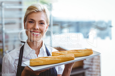 Pretty waitress carrying baguettes