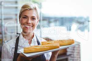 Pretty waitress carrying baguettes