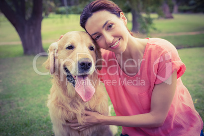 Pretty brunette looking at camera with her dog