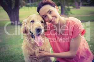 Pretty brunette looking at camera with her dog