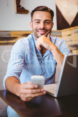 Smiling businessman using his laptop