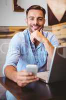 Smiling businessman using his laptop