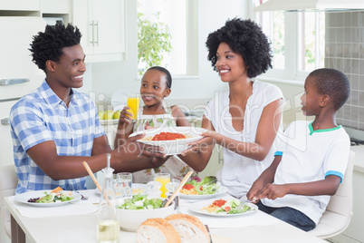 Happy family sitting down to dinner together