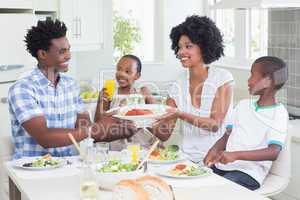 Happy family sitting down to dinner together