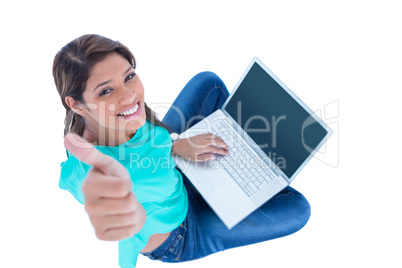 Happy pretty brunette looking at camera with thumbs up