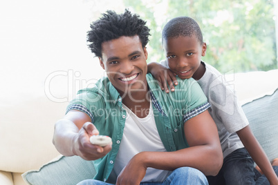 Father and son watching tv together on the couch Father and son watching tv together on the couch