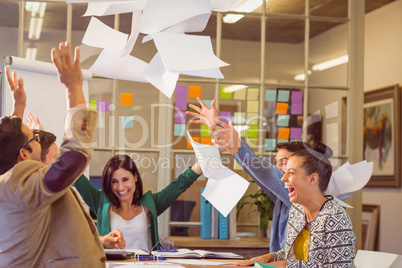 Celebrating business people throwing papers in the air