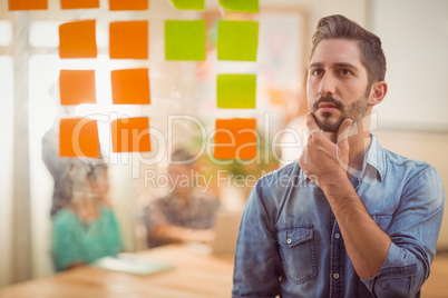 Concentrated businessman looking post its on the wall