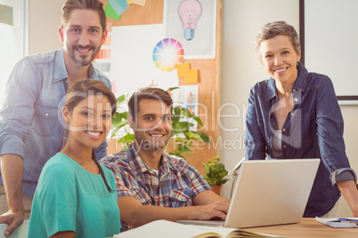 Colleagues using laptop at office