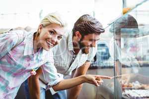 Cute couple on a date pointing cakes