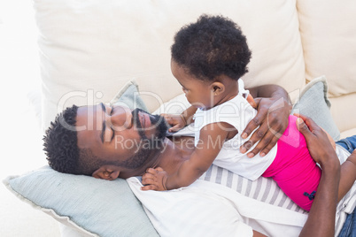 Happy father with baby girl on couch