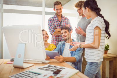 Creative business team discussing over a tablet