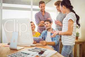 Creative business team discussing over a tablet