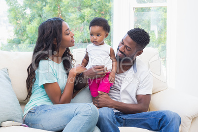 Happy parents with baby girl on couch