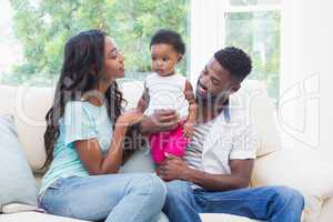 Happy parents with baby girl on couch