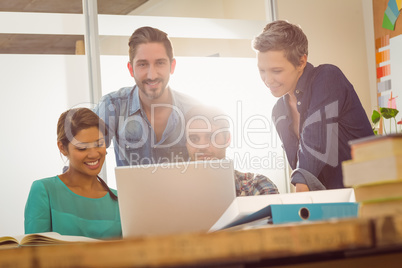 Colleagues using laptop at office