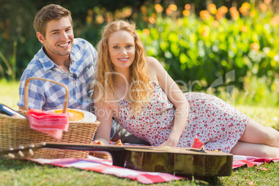 Young couple on a picnic looking at camera