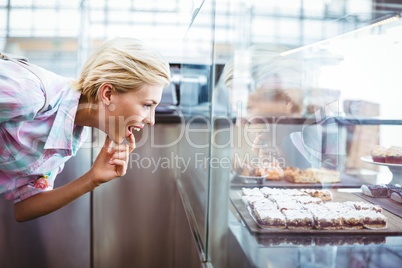 Puzzled pretty woman looking at cup cakes