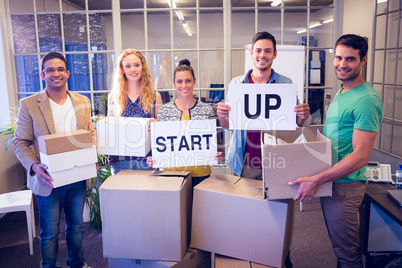 Creative business team holding cardboard written start up