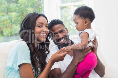 Happy couple with their baby girl on couch