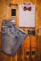 Shirt shoes jean glasses next to wallet and smartphone