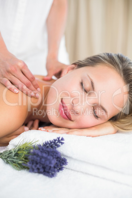Beautiful blonde lying on massage table with lavanda
