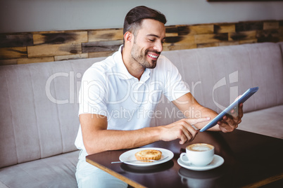 Young man having cup of coffee and pastry