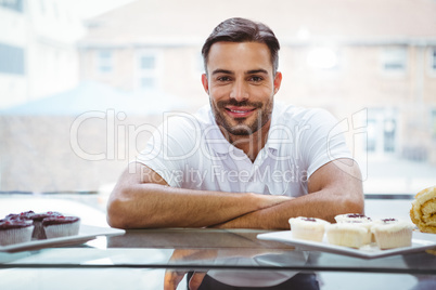 Smiling worker posing behind the counter