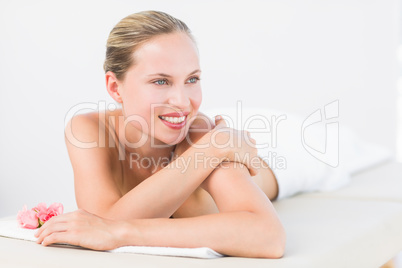 Peaceful blonde lying on towel smiling at camera