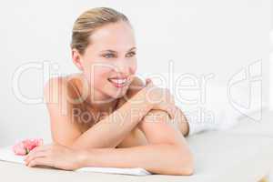 Peaceful blonde lying on towel smiling at camera