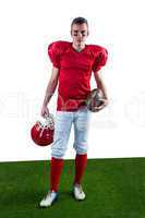 A serious american football player taking his helmet on her hand