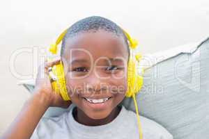 Little boy listening to music on the couch