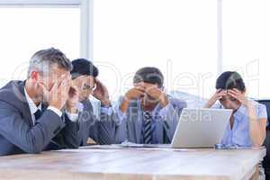 Colleagues with laptop and digital tablet in meeting